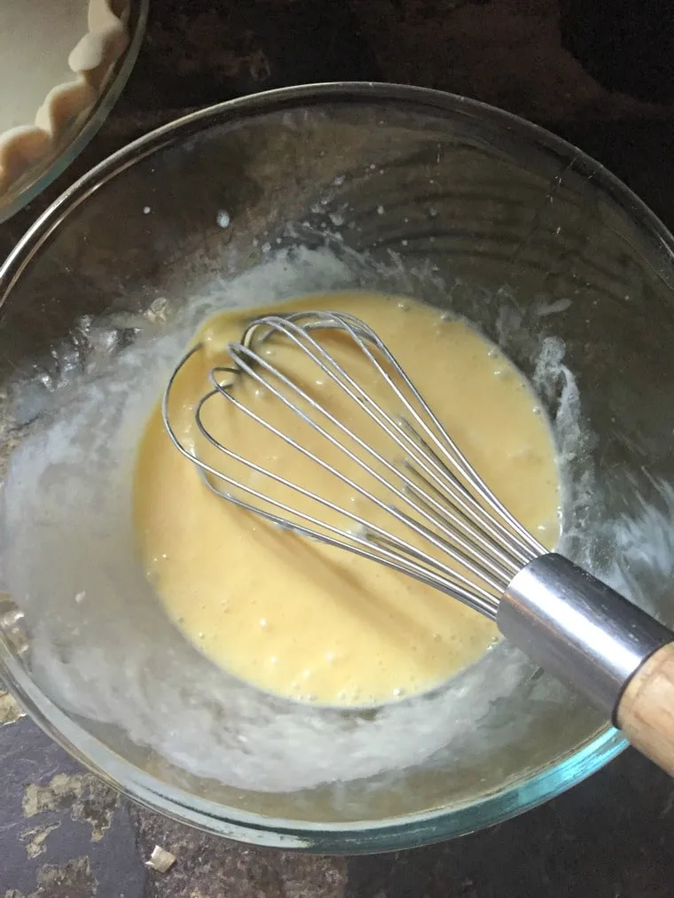 A photo of a bowl with the mixed ingredients inside and a whisk