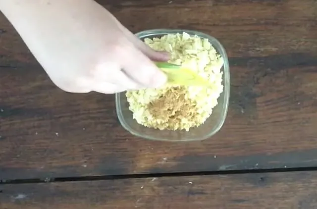 Hand adding packet of taco seasoning to crumb mix