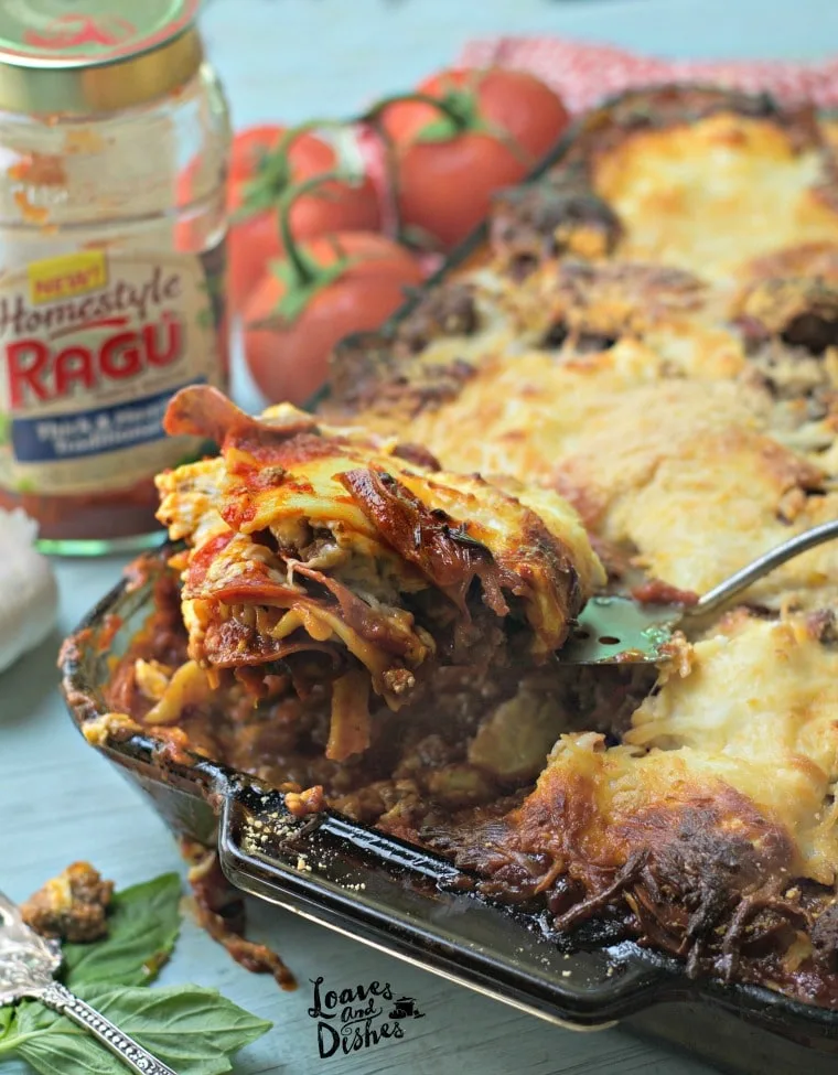 A photo of the lasagna being scooped out with the empty sauce jar in the background Cowboy Lasagna www.loavesanddishes.net