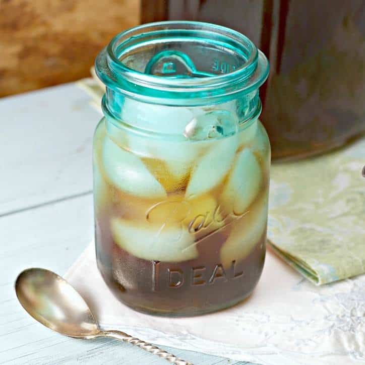 blue ball jar full of iced tea and ice with spoon