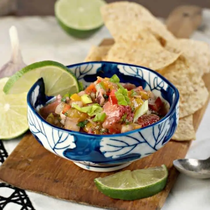 blue bowl of peach salsa with lime and chips