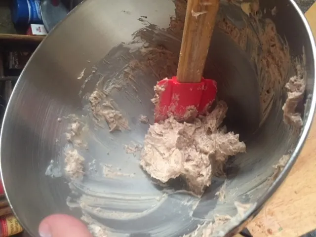 butter and chocolate mixed together in a silver bowl with spatula