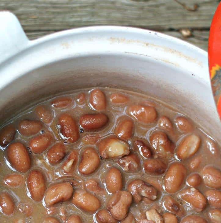 Close up of the pinto beans in a dutch oven showing the bean gravy and cooked shiny beans