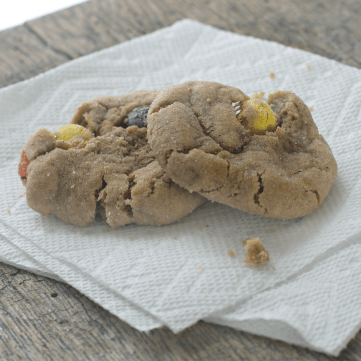 A photo of two CARAMEL M&M’S KICKING BROWN SUGAR COOKIES sitting on a paper towel looking like they are ready to eat. 