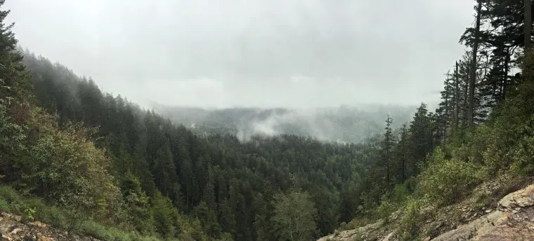 A photo of the mountain tops with fog and clouds laying on the mountain tops