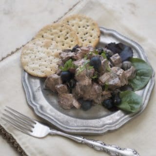 Blueberry Balsamic Chicken Salad on a pewter plate with crackers and fork to the side of the plate