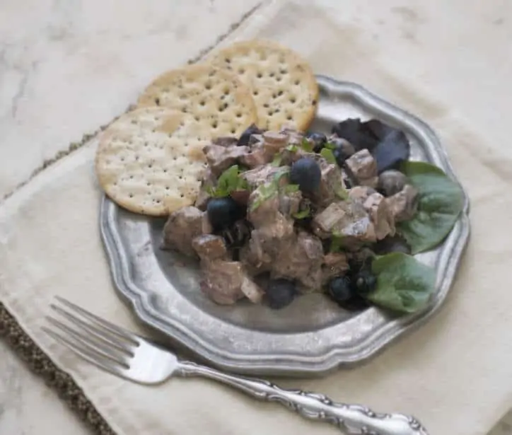 Blueberry Balsamic Chicken Salad on a pewter plate with crackers and fork to the side of the plate