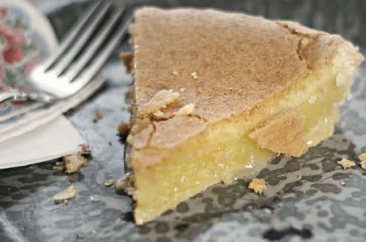 An upclose photo of Old Fashioned Chess Pie showing the gooey center starting to seep out onto the plate