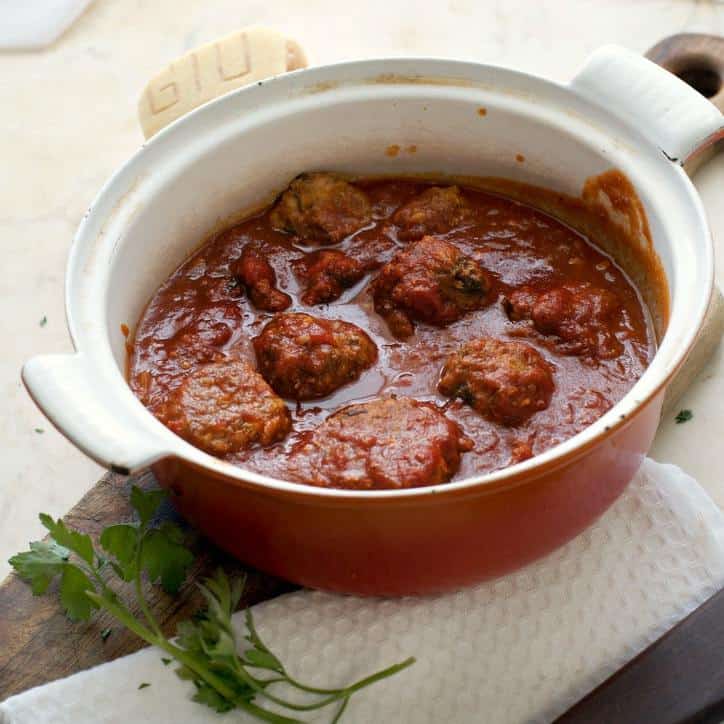 A photo of the meatballs without breadcrumbs in the pot they are cooked in slightly from the side