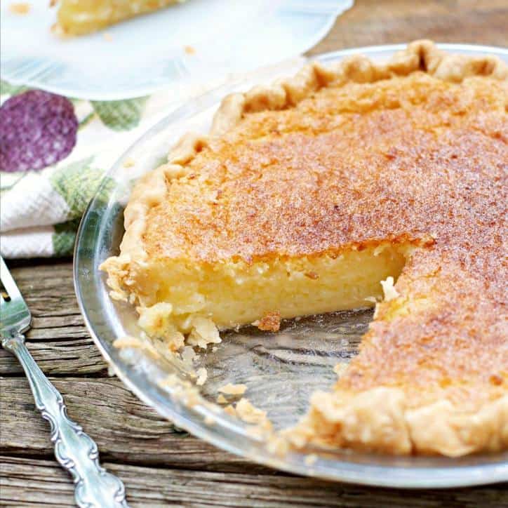 Pie with a slice cut out and it is turned so you can see the inside of the pie. Fork and towel in background