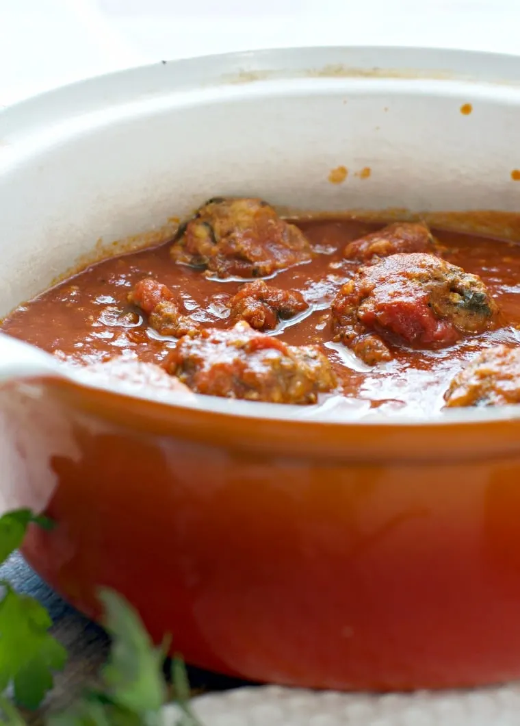 Orange sauce pan full of meatballs and tomato sauce