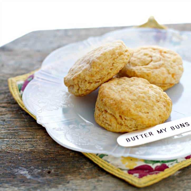 A photo of three Southern Sweet Potato Biscuits with a butter knife that says butter my buns on it