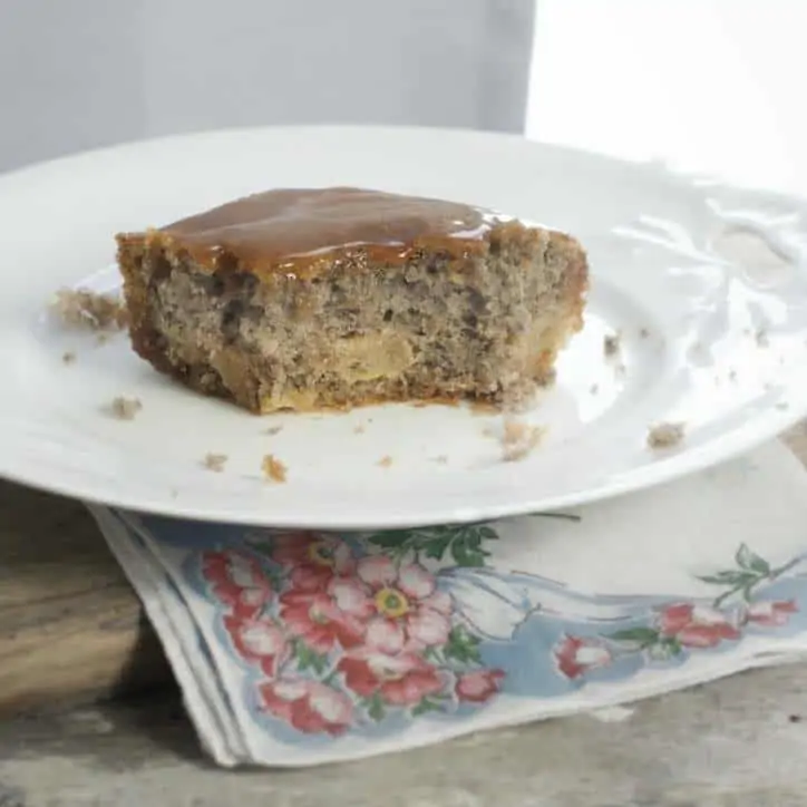 A photo of the cake with a bite out, you can see a bit of apple in the center. Fried Apple Cake with Caramel Icing