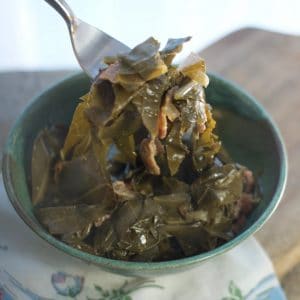 A photo of a fork full of greens THE SECRET TO PERFECT SOUTHERN COLLARD GREENS