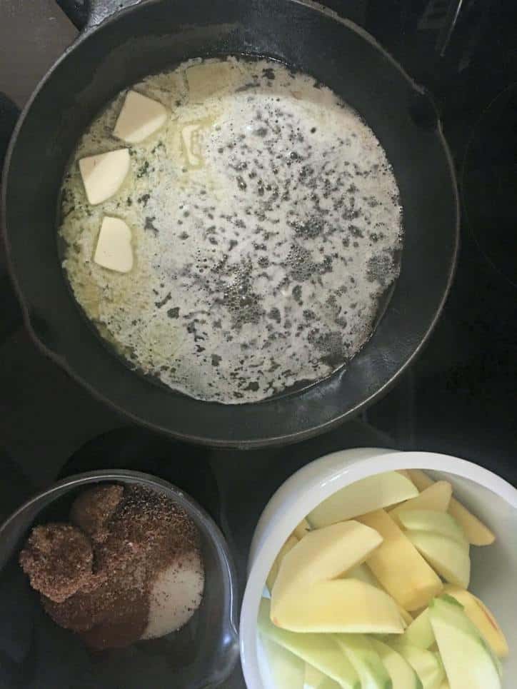 A photo of the melted butter in the pan with the waiting apples and spices