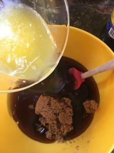 A photo of the melted butter being poured into the bowl with the sugars and karo Kentucky Bourbon Pie