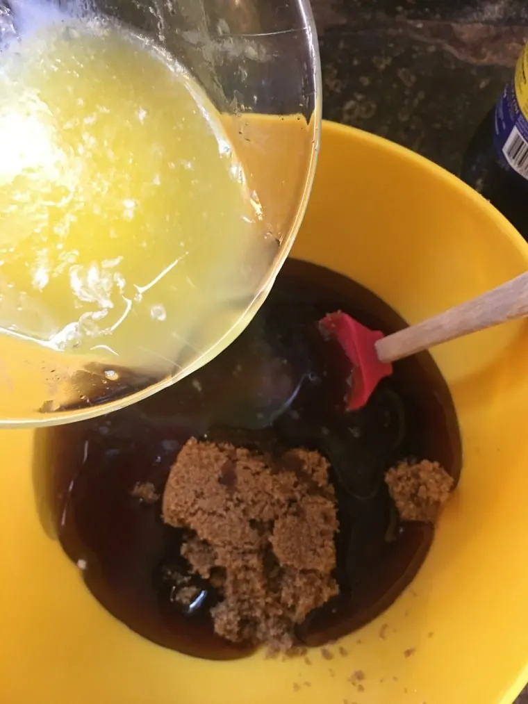A photo of the melted butter being poured into the bowl with the sugars and karo Kentucky Bourbon Pie
