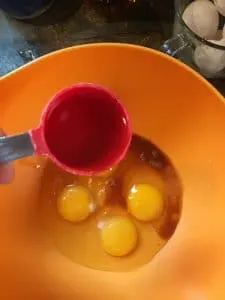 A photo of the bourbon being added to the eggs and the flavorings for Kentucky Bourbon Pie