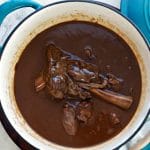 A photo of the prepared dish in the dutch oven from overhead Lamb Shanks in Wine Sauce