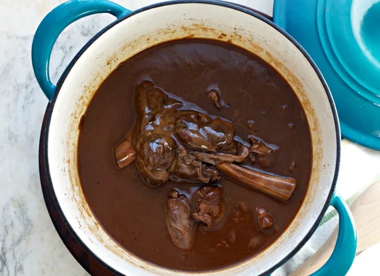 A photo of the prepared dish in the dutch oven from overhead Lamb Shanks in Wine Sauce
