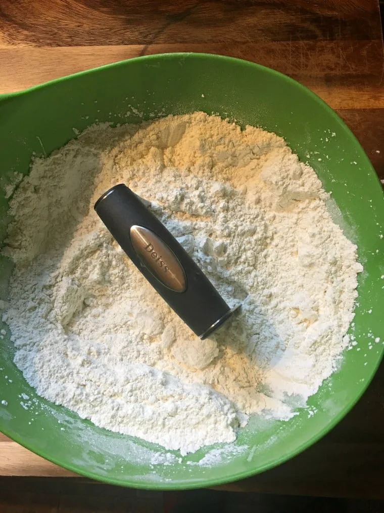 A photo showing the crisco being cut into the dry ingredients for Southern Buttermilk Biscuits