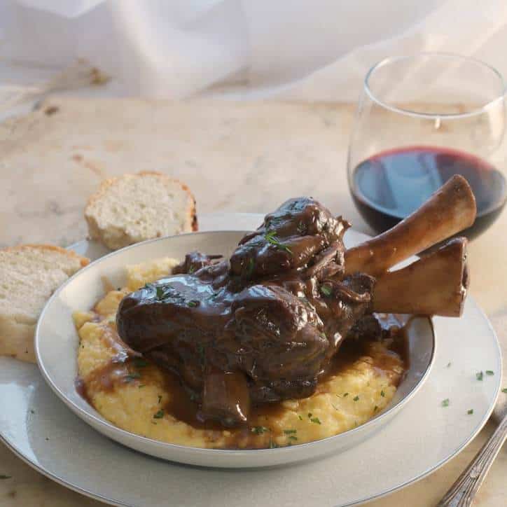 A photo of the prepared dish from the side Lamb Shanks in Wine Sauce
