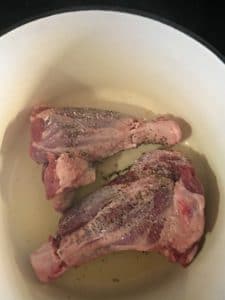 A photo of lamb shanks browning in oil - first side. Lamb Shanks in Wine Sauce