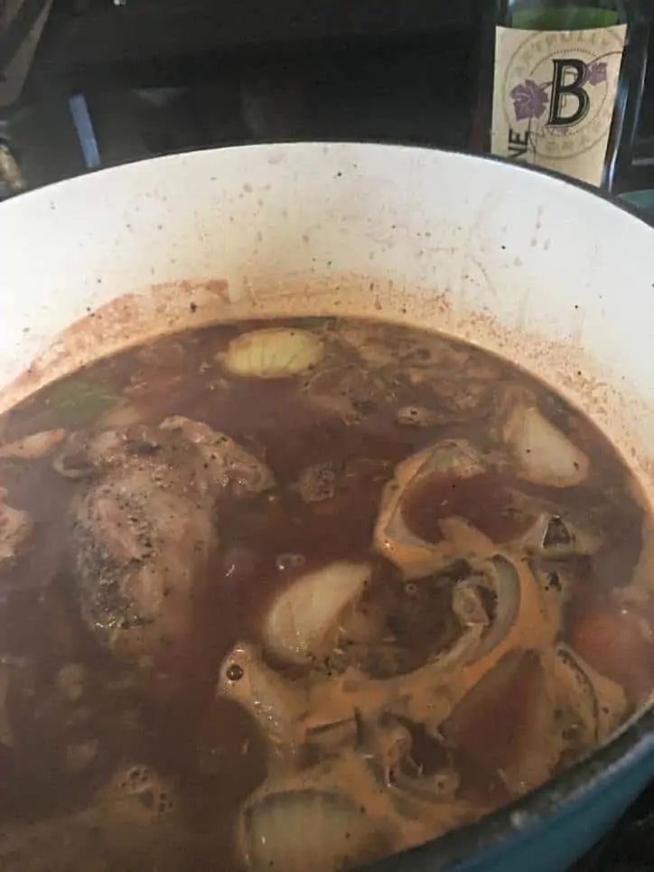 All of the ingredients added to the pot with pieces of onion and shank visible
