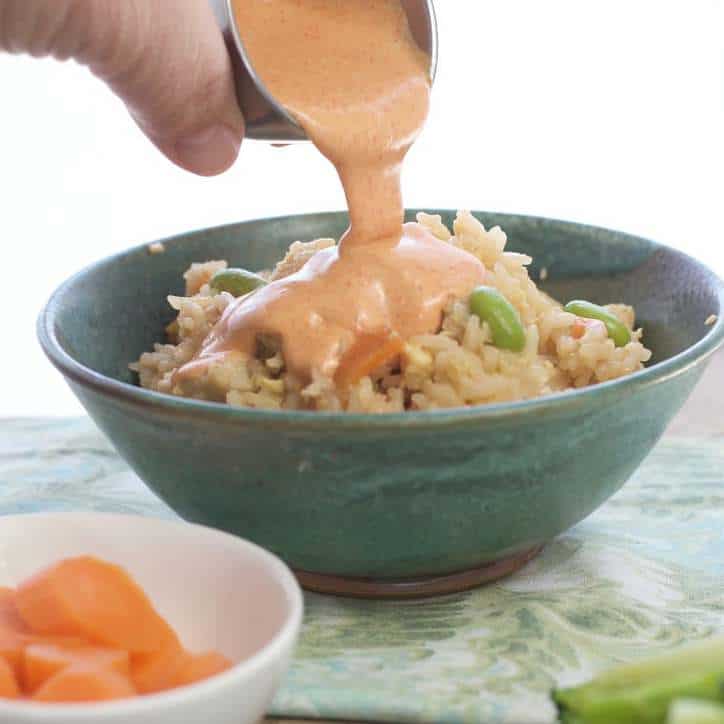 Shrimp Sauce being poured over a bowl of asian rice for the post Japanese White Sauce