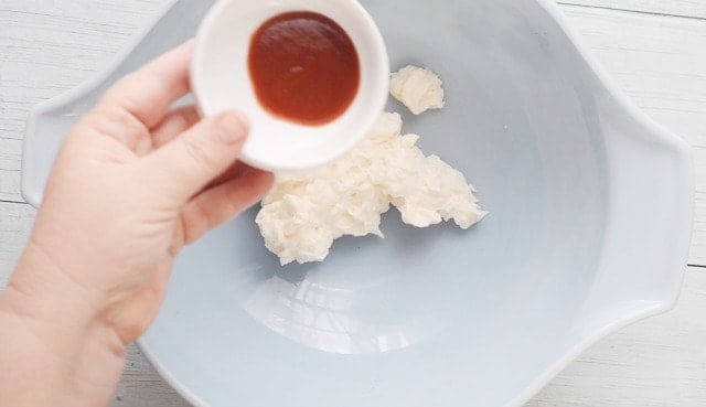 Blue bowl with mayonnaise in it and a smaller bowl with hot sauce