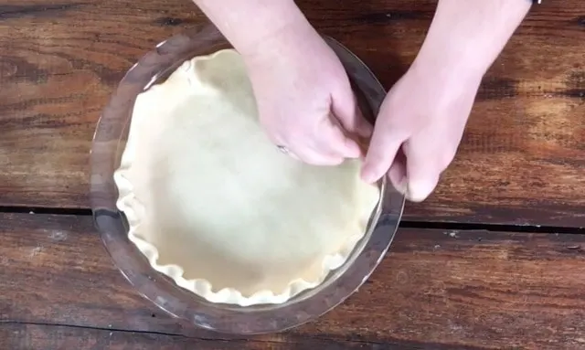 Lining a glass pie plate with a pie crust for sugar cream pie