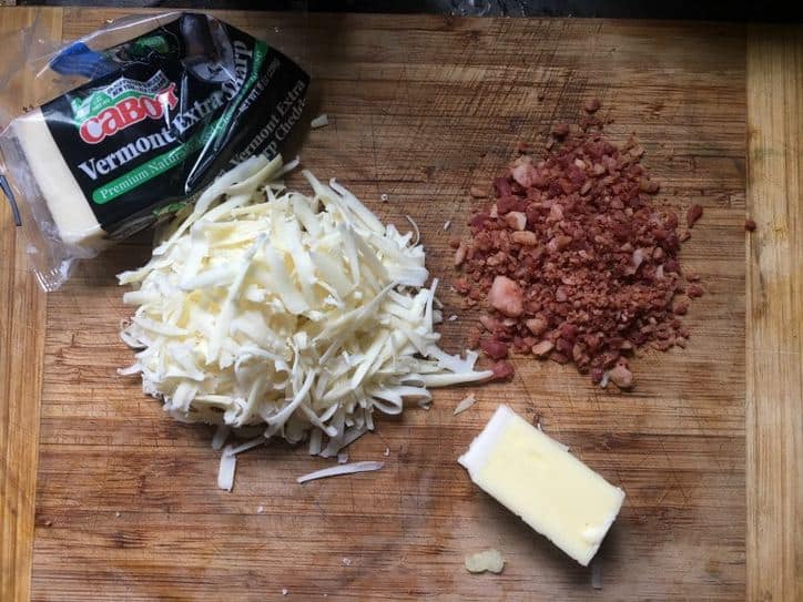 Cheese and bacon bits on a cutting board