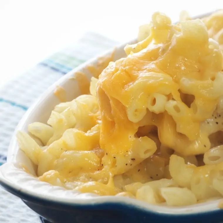 A photo of a spoonful of easy baked mac and cheese showing cheese pulls