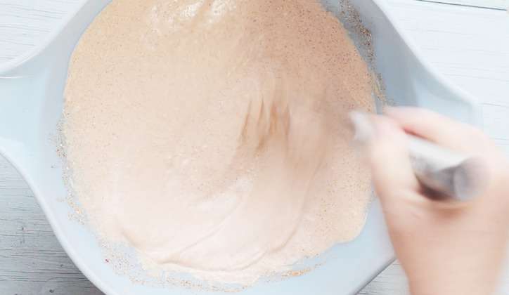 A blue bowl with ingredients being whisked