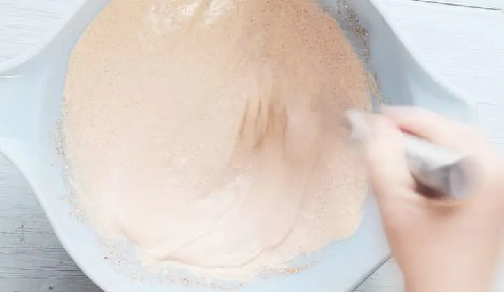 A blue bowl with ingredients being whisked