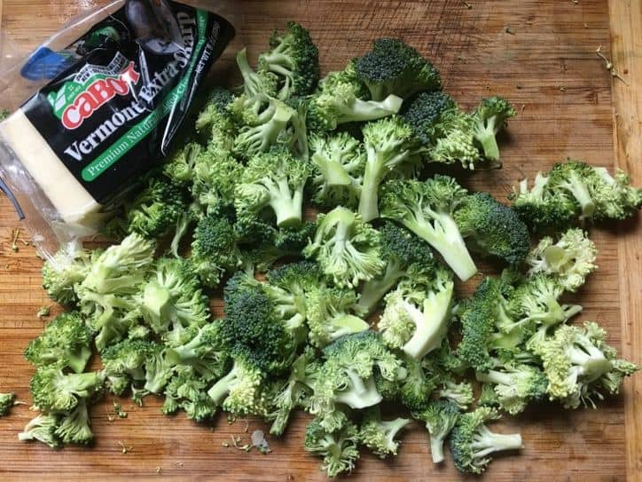 broccoli chopped and ready for blanching on cutting board with cheese 