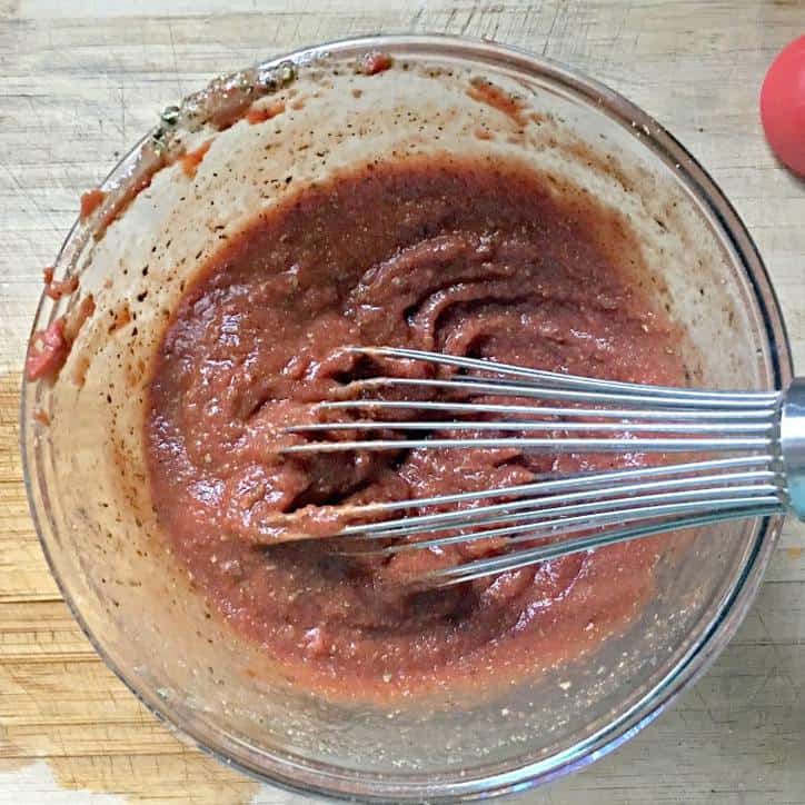 An overhead shot of the ingredients for easy pizza sauce from scratch in the bowl mixed up