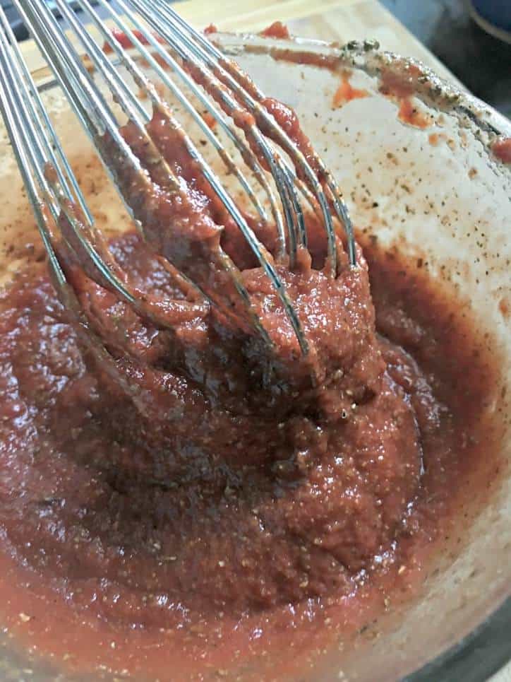 A close up photo of the easy pizza sauce from scratch with the whisk