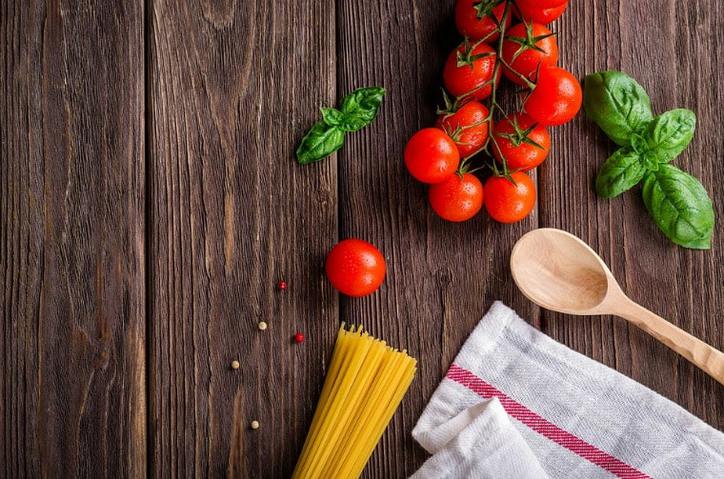 5 Cooking Hacks that Will Help You Reduce the Time Spent in the Kitchen Photo from overhead of tomatoes, spaghetti and a towel