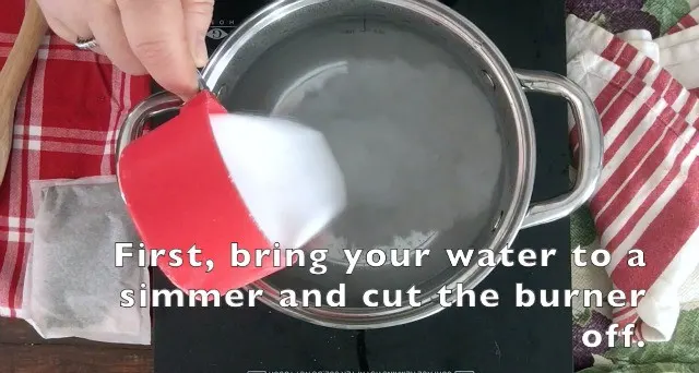1 cup of sugar being added to hot water in sauce pan