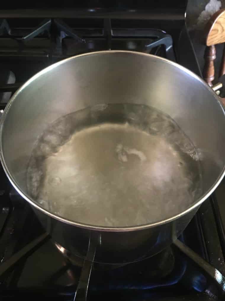 A photo of boiling water in a silver sauce pan