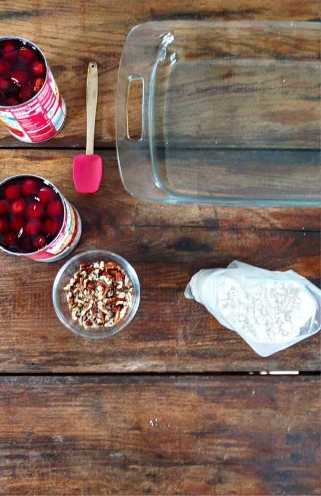 BAKING DISH, PECANS, CANNED CHERRIES CAKE MIX AND A SPATULAT