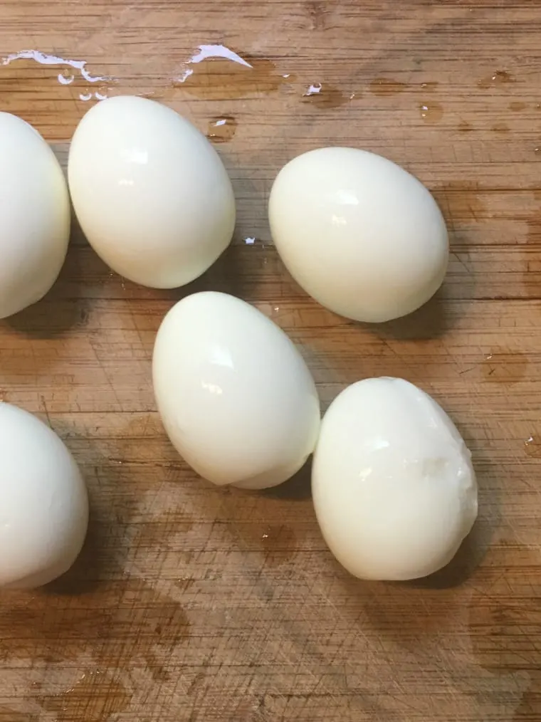 A photo of six boiled Eggs on cutting board. 