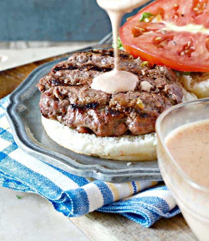 A photo of Appalachian Mountains Tiger Sauce being poured on a burger