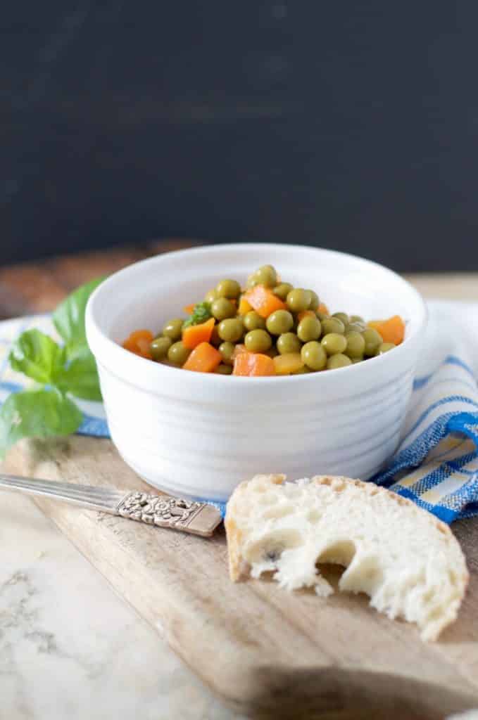 A photo from the side with a piece of bread of HOW TO COOK CANNED PEAS AND CARROTS