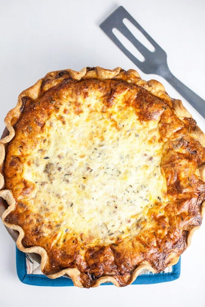 A photo from above with a serving fork of Meat Lovers Quiche