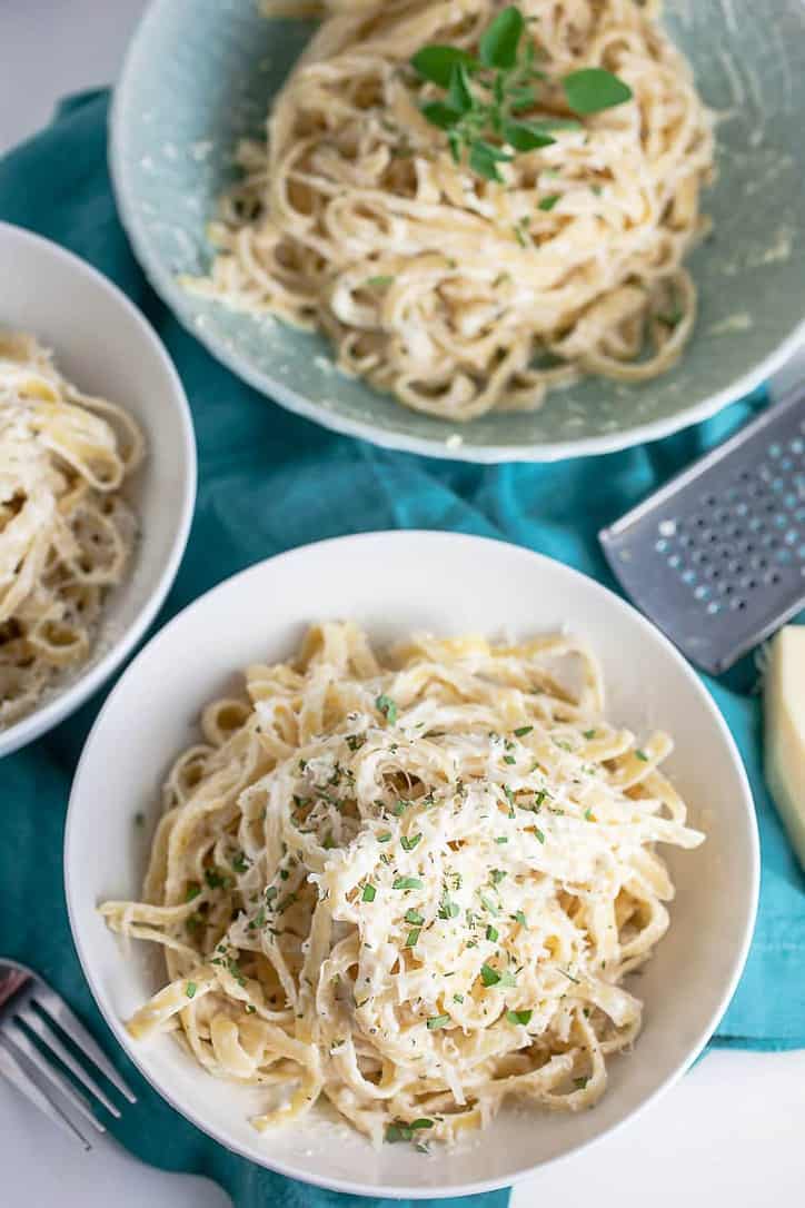 A photo of three bowls of fettuccini Alfredo pasta sauce