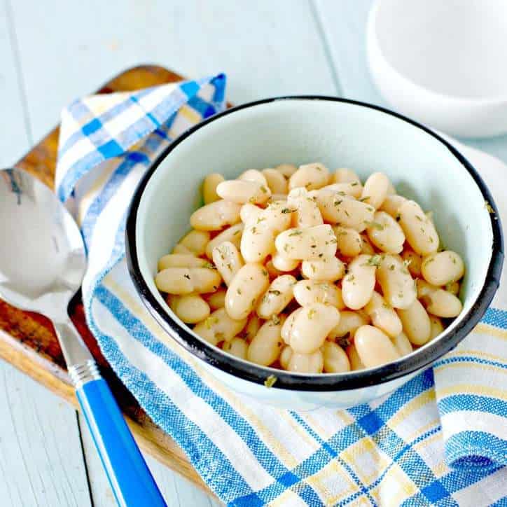 overhead shot of canned navy beans in a blue bowl