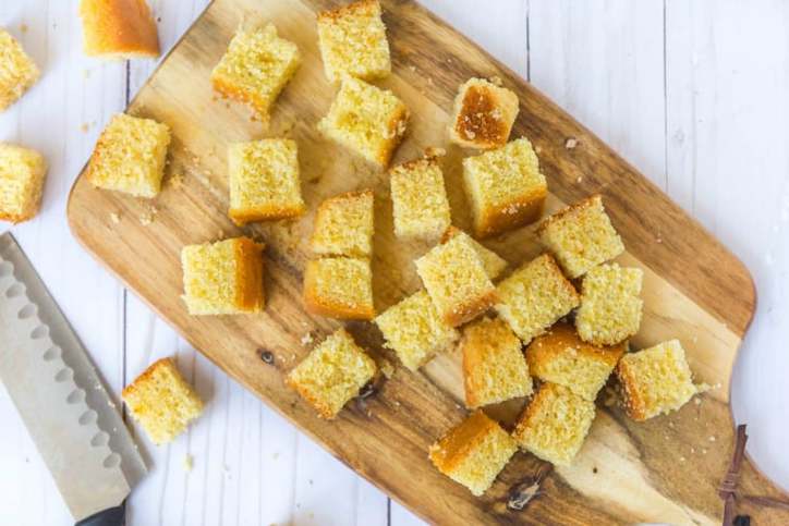 The cornbread cut into cubes on a cutting board