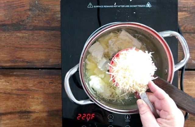 Adding a cup of parmesan cheese to the butter and cream cheese mixture in the sauce pan on the stove top